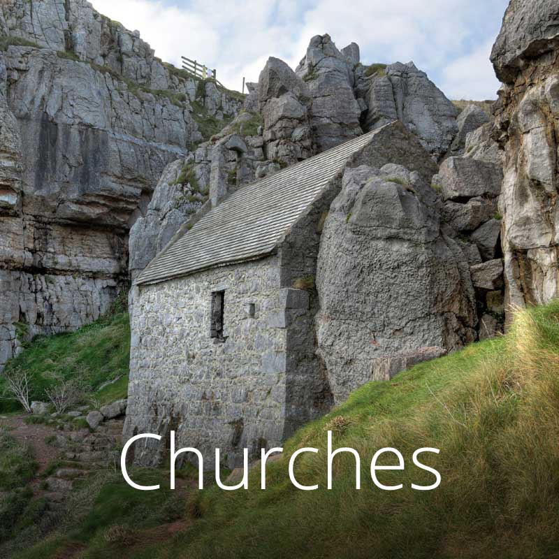 Tiny St Govan's chapel shelters below cliffs on teh rugged Pembrokeshire coast