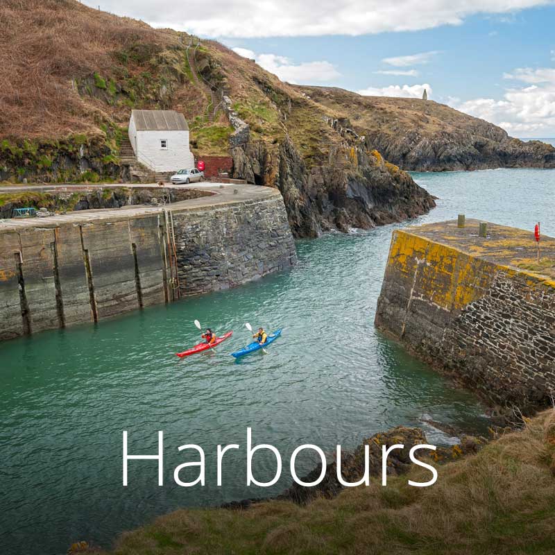 Porthgain Harbour with kayakers, in Pembrokeshire